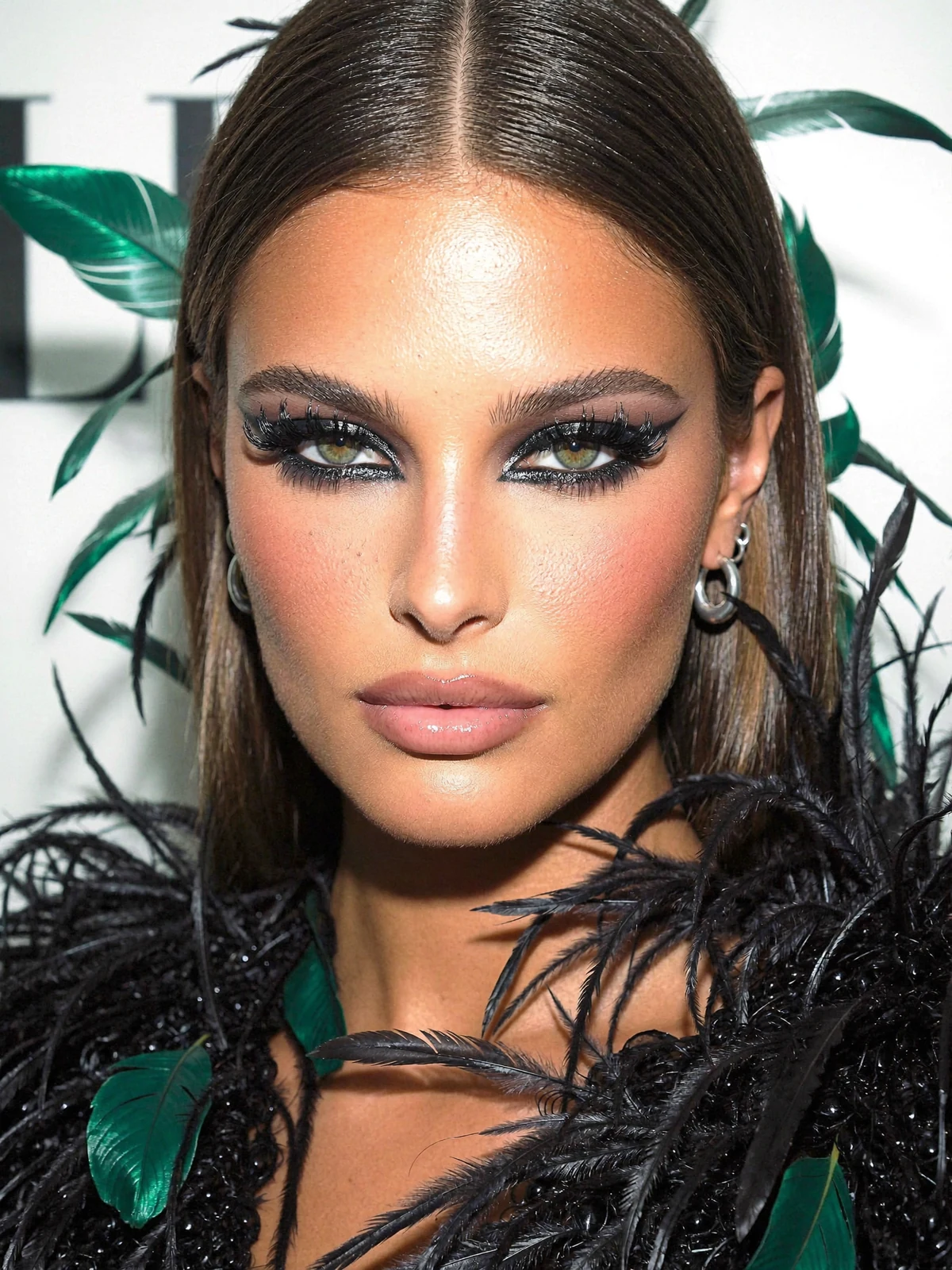 Dramatic smoky-eye makeup and black feathers